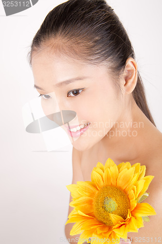 Image of Beautiful young Asian girl with bright yellow sunflower