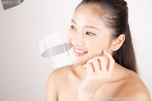 Image of Beautiful young Asian girl with one hand on face