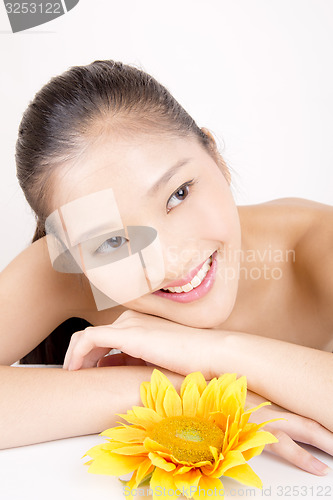 Image of Beautiful young Asian girl with bright yellow sunflower