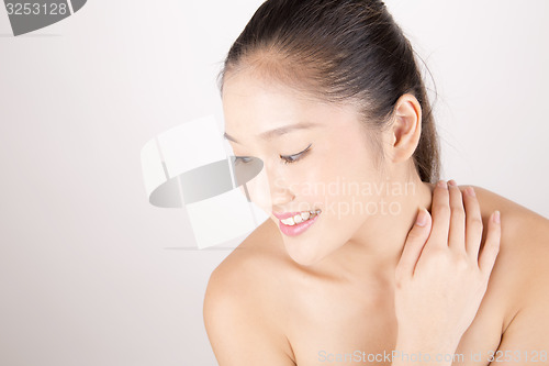 Image of Beautiful young Asian girl with one hand on shoulder