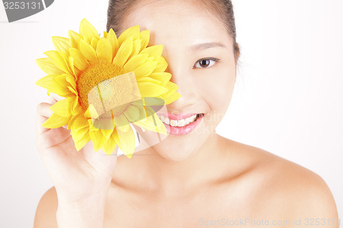 Image of Beautiful young Asian girl with bright yellow sunflower