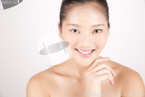 Image of Beautiful young Asian girl with one hand on face