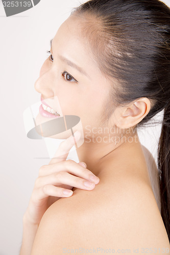 Image of Beautiful young Asian girl with one hand on shoulder