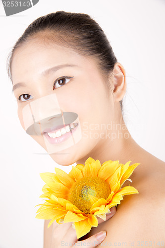 Image of Beautiful young Asian girl with bright yellow sunflower