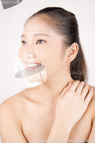Image of Beautiful young Asian girl with one hand on shoulder