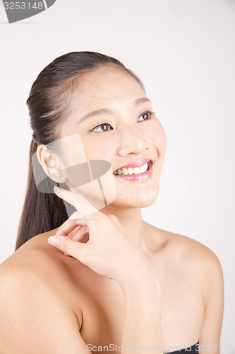 Image of Beautiful young Asian girl with one hand on face