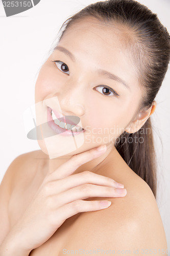 Image of Beautiful young Asian girl with one hand on face