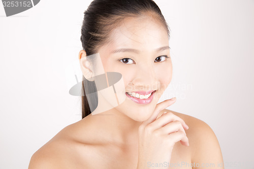 Image of Beautiful young Asian girl with one hand on face