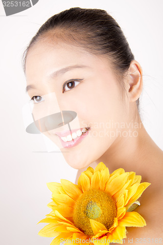 Image of Beautiful young Asian girl with bright yellow sunflower
