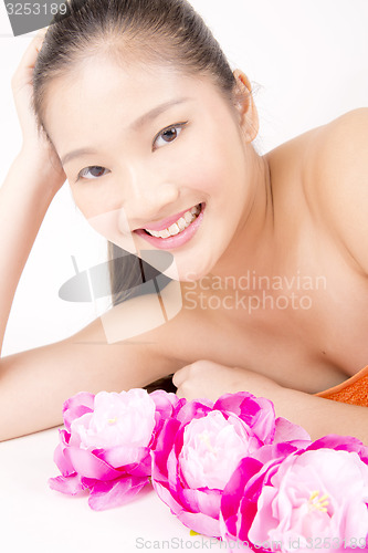 Image of Beautiful young Asian girl lying down with red peony flowers