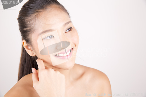 Image of Beautiful young Asian girl with one hand on face