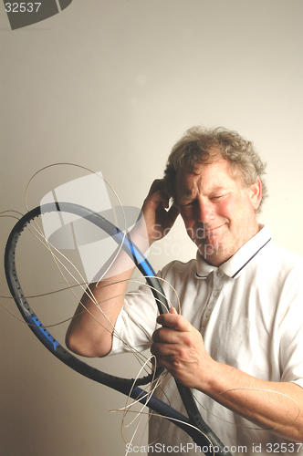 Image of man with tennis frame and strings