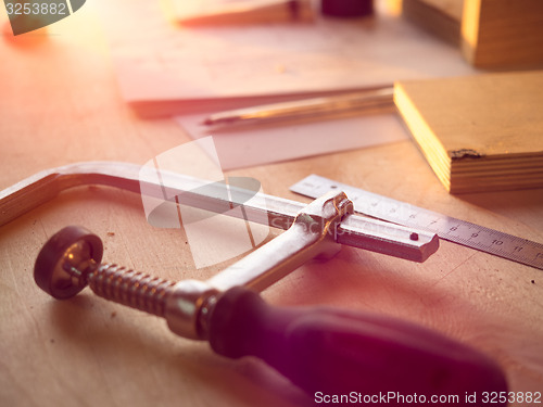 Image of Real woodworking shop: clamps holding workpiece gluing, close-up