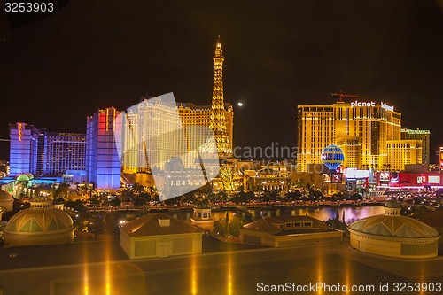 Image of Night view of the dancing fountains of Bellagio and the Eiffel Tower replica of Paris Las Vegas Resort in Las Vegas Nevada, USA 