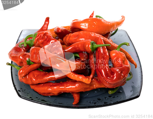 Image of Wet red chili peppers on glass plate