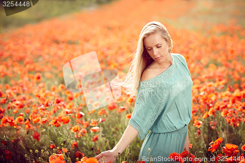Image of Beautiful woman on poppy flower field