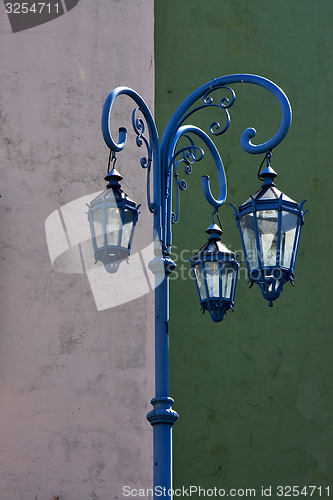 Image of blue street lamp  and a green white  wall 