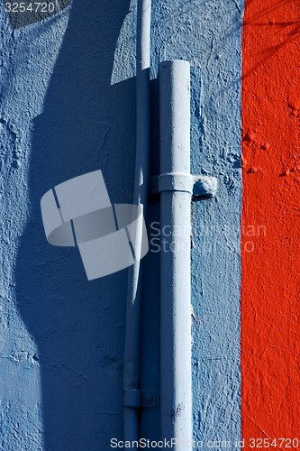 Image of blue colored pipe and red wall 