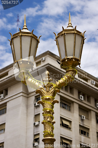 Image of  gold street lamp and a  palace 