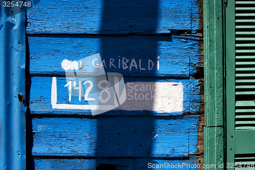 Image of green wood venetian blind and a blue garibaldi wall