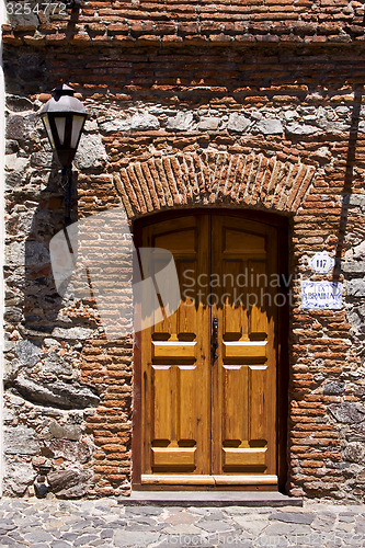 Image of brown wood old door and a street lamp