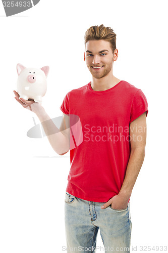 Image of Handsome young man holding a piggy bank