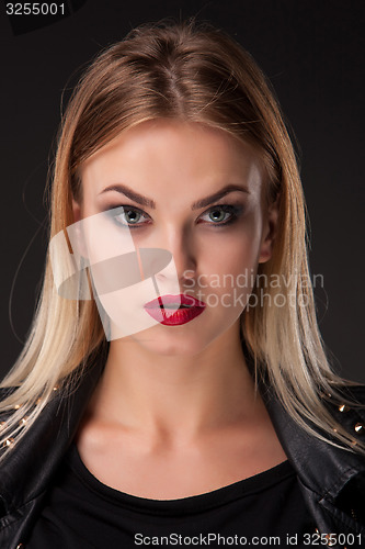 Image of ortrait of beautiful model with long blond hair on black background