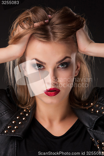 Image of ortrait of beautiful model with long blond hair on black background