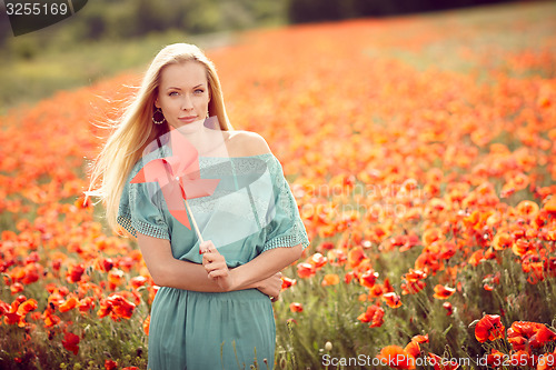 Image of Beautiful woman on poppy flower field