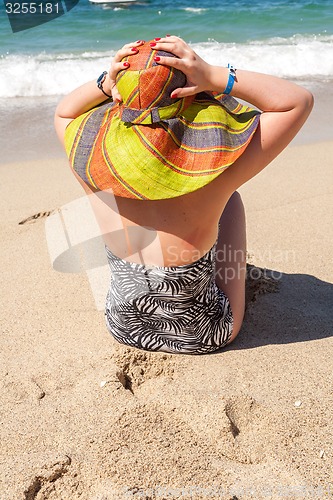 Image of woman in hat on the beach