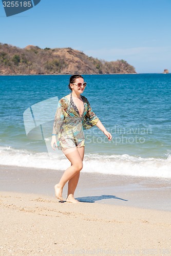 Image of woman walking away on the beach