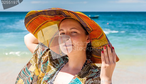 Image of woman in hat on the beach
