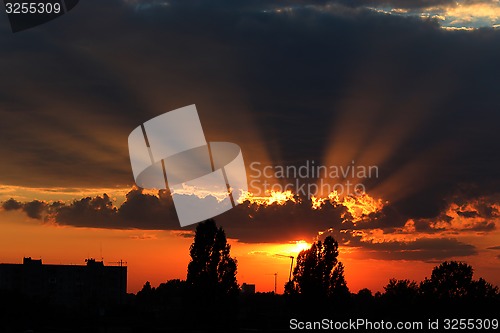 Image of beautiful summer sunset with dark sky and sun