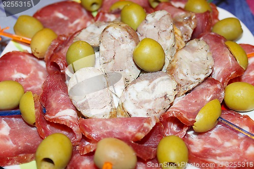 Image of sausage cutting into pieces and olives