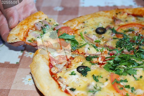 Image of man takes a piece of tasty pizza from plate