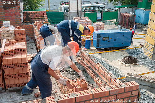 Image of Team of bricklayers on house construction