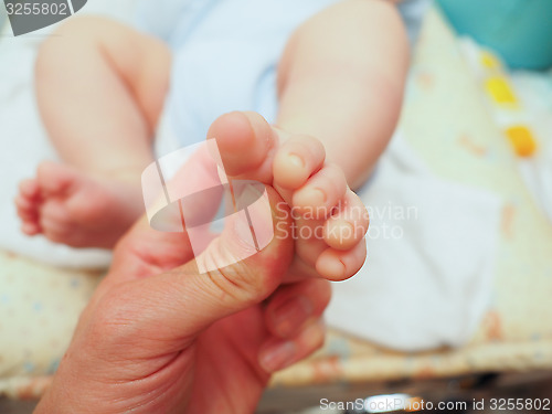 Image of Baby receiving foot massage after diaper change with a thumb