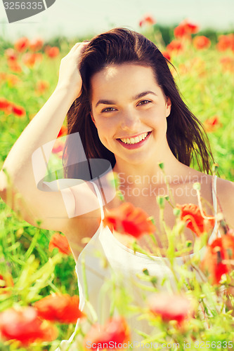 Image of smiling young woman on poppy field