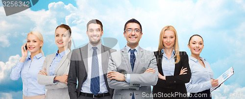 Image of group of smiling businessmen over blue sky