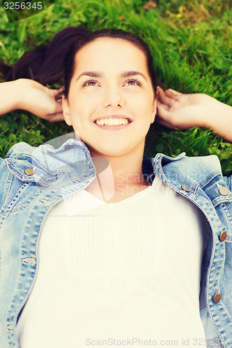 Image of smiling young girl lying on grass