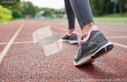 Image of close up of woman feet running on track from back