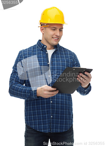 Image of smiling man in helmet with clipboard