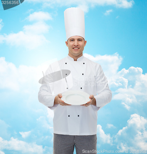 Image of happy male chef cook showing empty plate