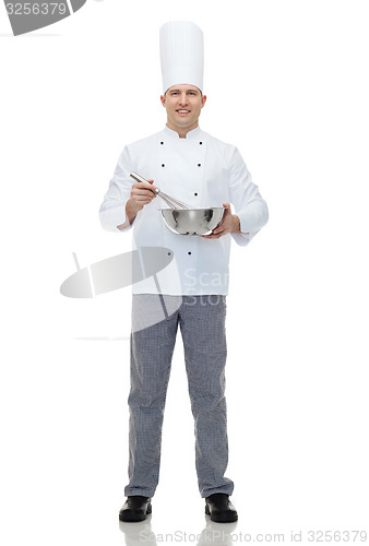 Image of happy male chef cook whipping something with whisk