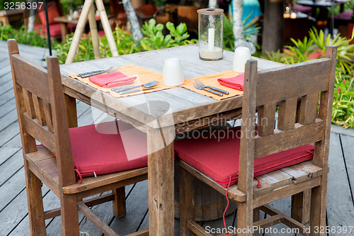 Image of close up of cutlery with glass and napkin on table