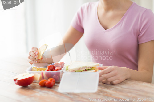 Image of close up of woman with food in plastic container