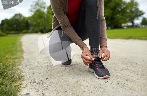 Image of close up of woman tying shoelaces outdoors