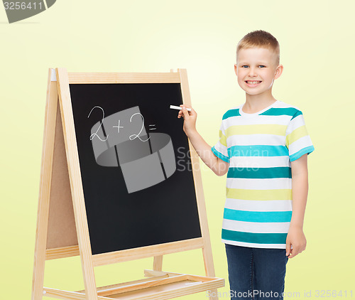 Image of happy little boy with blackboard and chalk