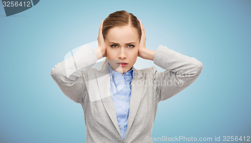 Image of stressed businesswoman with covered ears