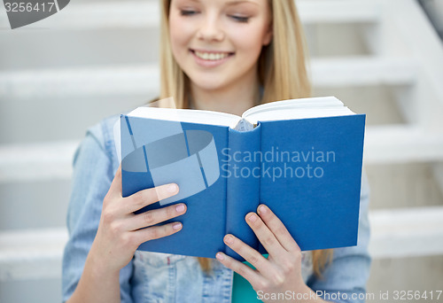 Image of close up of young woman reading book at school